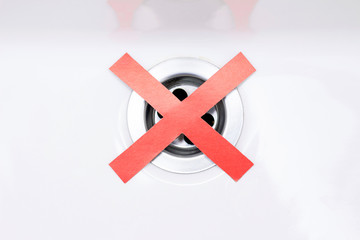 sink clogging concept. Do not drain the water. Drain in the sink does not work, clogged. Red cross...