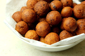 Small balls of freshly baked homemade cottage cheese in the white paper. Freshly made donuts from cottage cheese