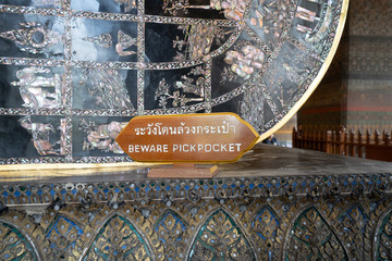 Sign cautioning tourists of pickpockets at Wat Pho in Thailand (English translation - Beware Pickpockets)