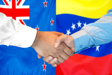 Business handshake on the background of two flags. Men handshake on the background of the New Zealand and Venezuela flag. Support concept