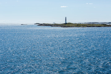 Insel mit Leuchtturm vor der Küste Norwegens