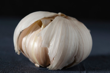 The garlic, garlic cloves and skin on the dark background.