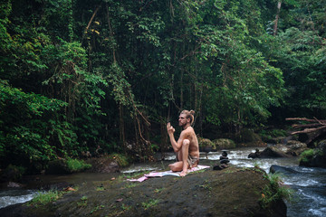 Fototapeta na wymiar Yoga practice and meditation in nature. Man practicing near river