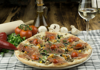 Declicious pizza with ingredients on the side, backed in traditional wooden oven.