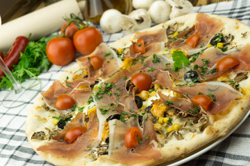 Declicious pizza with ingredients on the side, backed in traditional wooden oven.