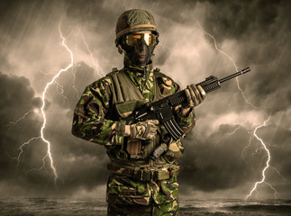 Armed soldier standing in rainy obscure weather