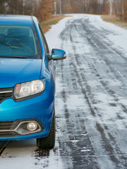 GOMEL, BELARUS - December 4, 2019: A blue passenger car stands on the side of a snowy forest road.