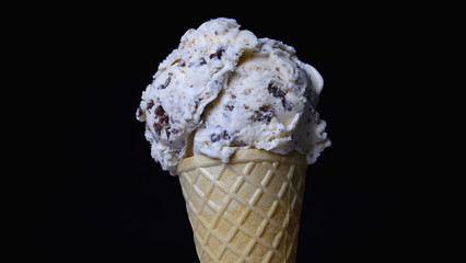 Cookies & Cream ice cream scoop in waffle cone on black background, Closeup Front view Food concept..