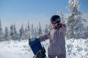 Young snowboarder in the mountains on top. Active rest on a snowboard.