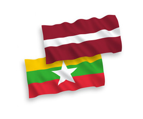 National vector fabric wave flags of Latvia and Myanmar isolated on white background. 1 to 2 proportion.