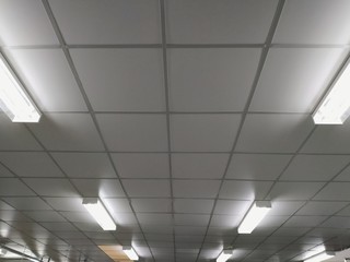 The white ceiling in the building with light long-fluorescent lamps is illuminating.