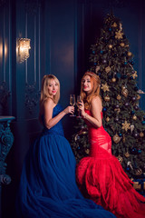 Gorgeous Women, ladies in perfect evening dreses with feathers and sparkle at living room, Holidays time