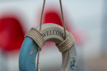 Decorative lifebuoy with the welcome sign hanging on the rope
