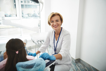Fototapeta premium Happy female dentist conducting a check up