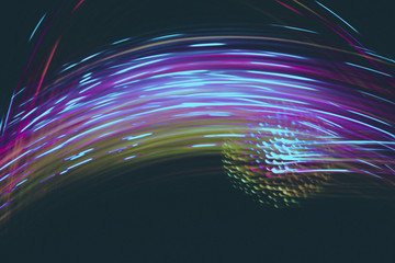 Abstract blurred space comet, multi-colored light lines on a black background.