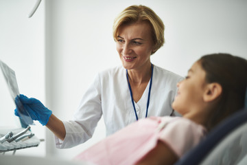 Obraz premium Positive professional dentist holding a dental scan