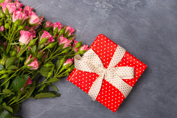 Fototapeta premium Close-up Pink spray roses gift in red box on grey background Woman's Day Mother's St. Valentine's Day concept Copy space