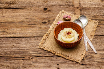 Homemade Thanksgiving garlic mashed potatoes with salt and pepper. Sackcloth napkin, spoons, old wooden boards background