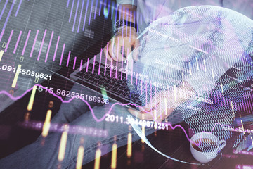 Forex graph with businessman working on computer in office on background. Concept of analysis. Double exposure.