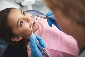 Close up of a smiling little girl enjoying dentist check up
