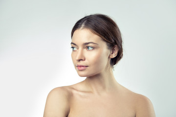 Young beautiful woman with bare shoulders, beauty portrait on a light background.