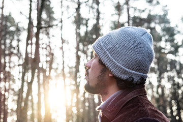 Man looking up in a forest, hopeful expression, 