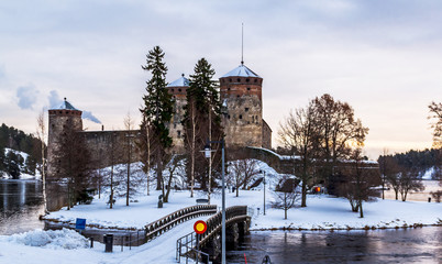 Medieval fortress Olavinlinna on Saimaa lake on a cloudy winter day. Savonlinna, Finland.
