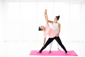 Obraz premium Two Asian woman practice yoga exercise.