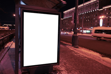 Vertical advertising city billboard format in the bus stop. bus stop in winter in the city at night. Ad design MOCKUP with white field.