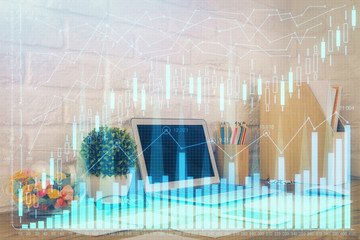 Double exposure of graph and financial info and work space with computer background. Concept of international online trading.