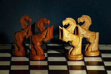 Chess pieces a white and black horse are on a chessboard.