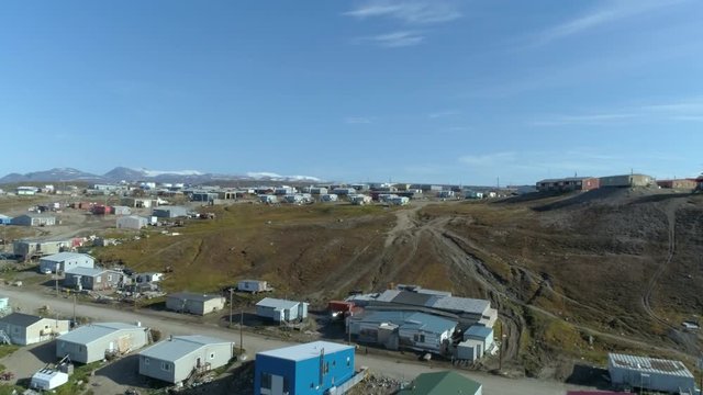 Drone, aerial, wide shot of homes and trailers on hilly ground.