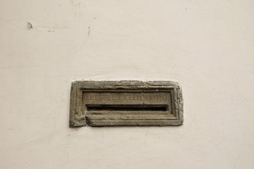 Close-up of an old, stone mailbox with the engraving 