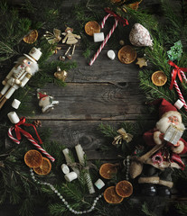Christmas wreath, a composition of new year toys, pine branches, oranges, sweets, on the background of an old wooden texture