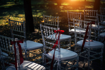 Row of chairs for outdoor wedding ceremony, close-up. Chairs are prepared for the reception.
