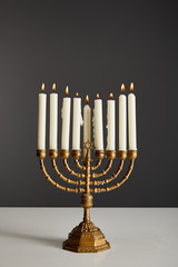 burning candles in menorah isolated on grey