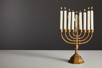 burning candles in menorah isolated on grey