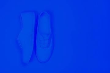 Sports trend background with sneakers and copy space. Tinted blue color.