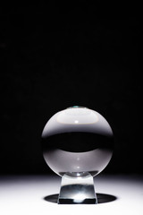 crystal ball on white surface on black background