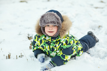 Fototapeta na wymiar walking funny little boy in the winter. child outdoors.