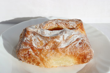 Freshly baked puff pastry with cottage cheese. European breakfast. Baking on a white plate.