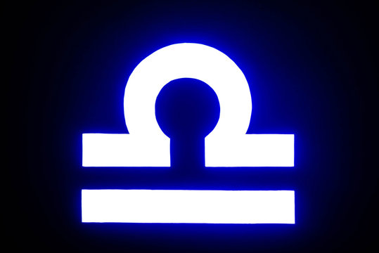 blue illuminated Libra zodiac sign isolated on black