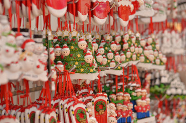 Cute Santa Claus toy dolls key chains placed in a shelf for gifting to during Christmas season in winters. Little Santa figurines are popular gifts for kids during the festivities