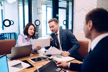 Young coworkers discussing project in office