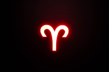 red illuminated Aries zodiac sign on black background