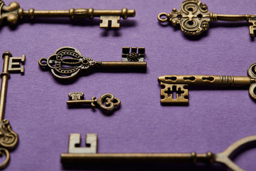 close up view of vintage keys on violet background