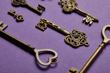 close up view of vintage keys on violet background