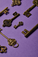 close up view of vintage keys on violet background