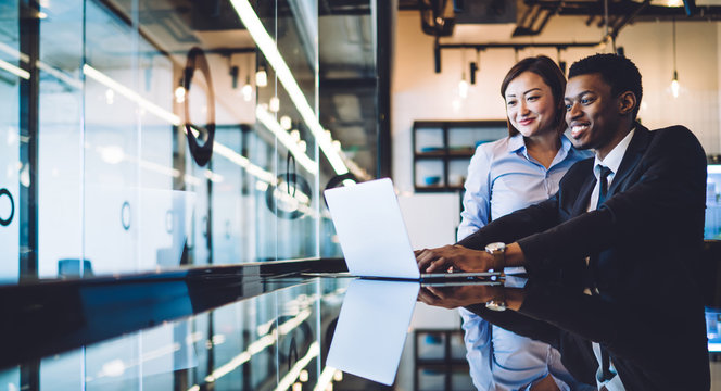 Diverse Coworkers Using Laptop In Modern Office