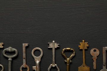 Fototapeta na wymiar flat lay with vintage rusty keys on black background